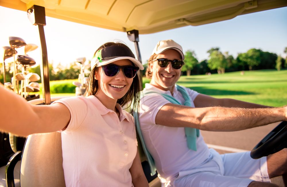 A couple smiling together in a golf cart