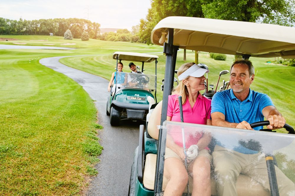 A group of friends riding golf carts along the course
